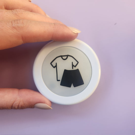 Hand holding personalised morning routine push light with get dressed icon on lavender background